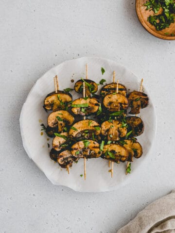 grilled mushrooms garnished with parsley on a plate