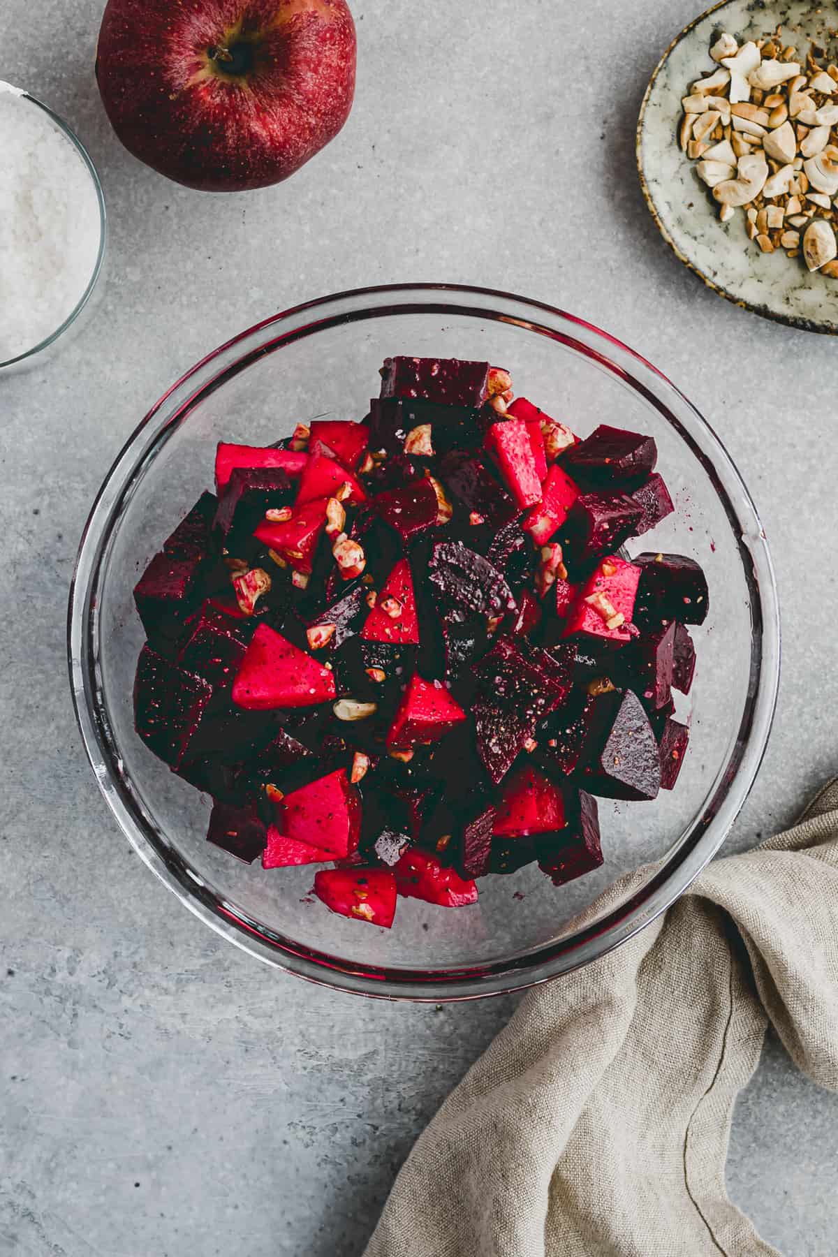 beet apple salad with cashew nuts in a glass bowl