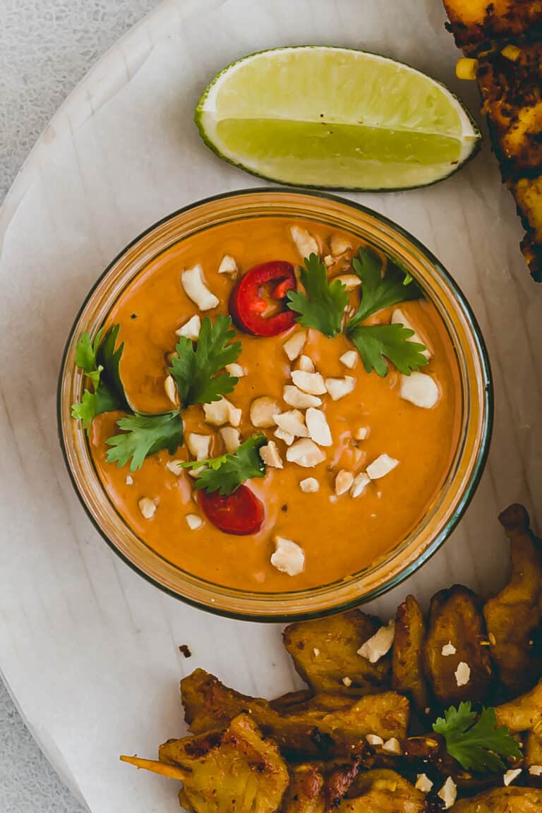 satay sauce in einer schüssel neben etwas limette