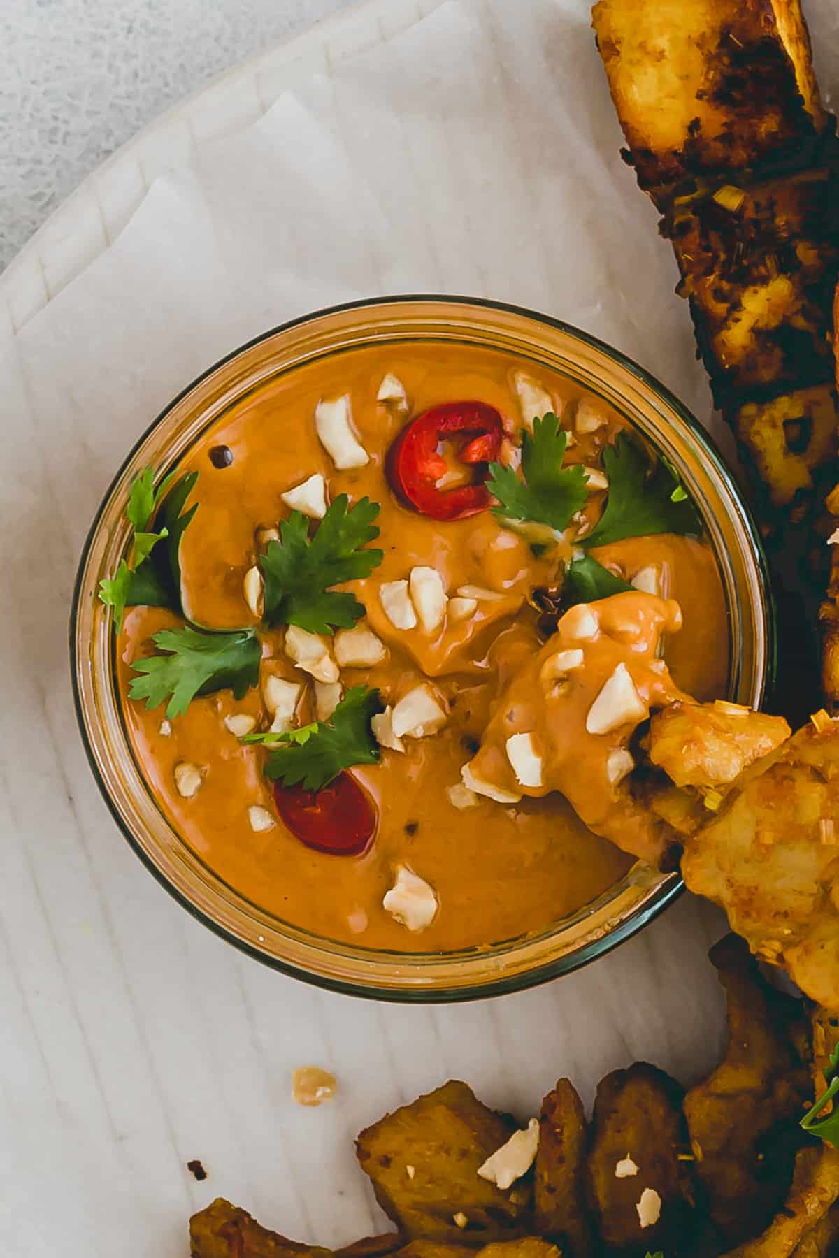 satay sauce topped with cilanto, chili, and peanuts
