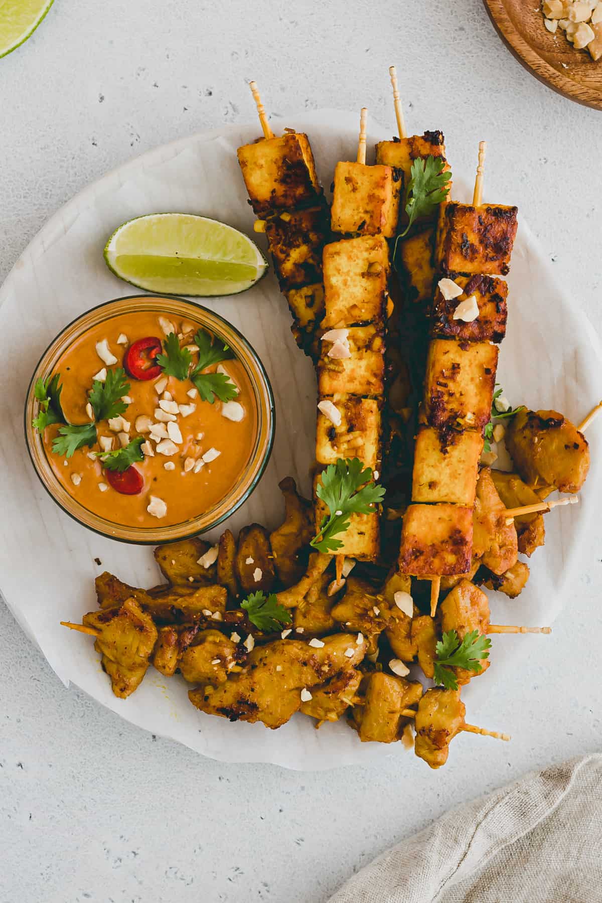 vegan satay skewers on a plate with peanut dipping sauce