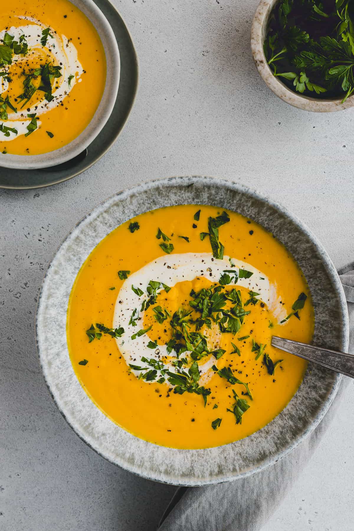 two bowls filled with homemade vegan carrot coconut soup