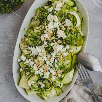 raw zucchini salad with feta on a serving platter