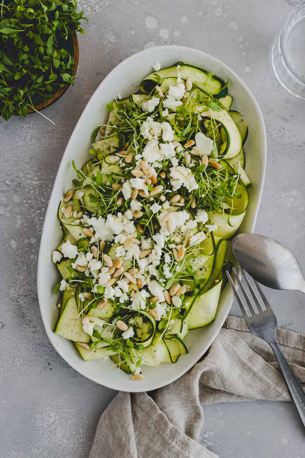 raw zucchini salad with feta on a serving platter