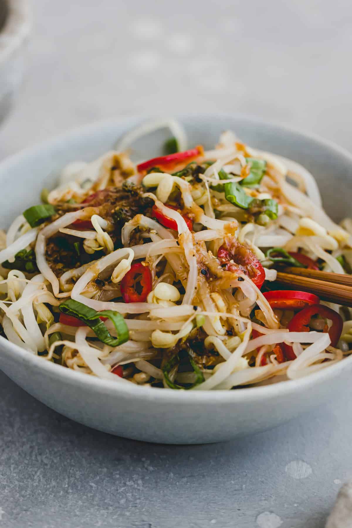 mung bean sprout salad with asian dressing, chili, and scallion in a small bowl