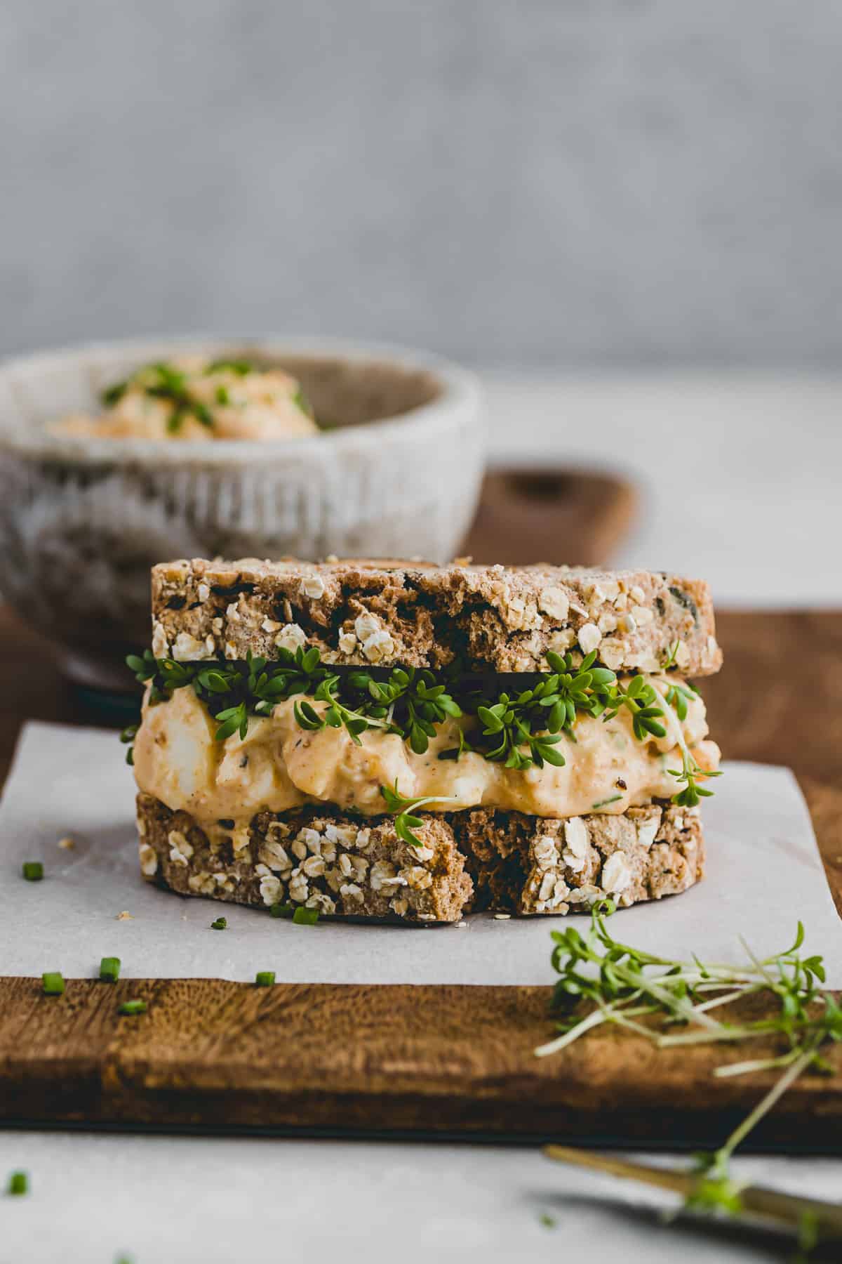 sandwich with egg salad and garden cress on a chopping board