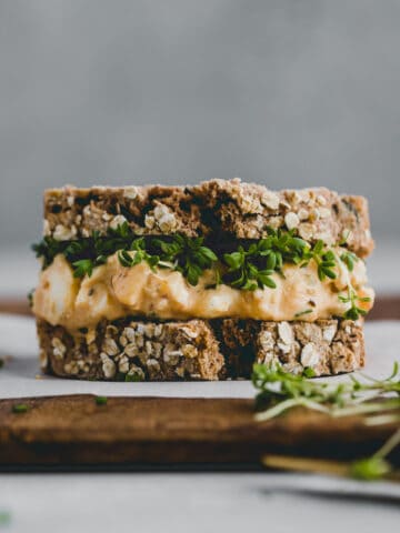 egg salad sandwich with garden cress on a chopping board
