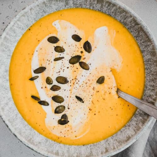 Kürbis Apfel Suppe einer Suppenschüssel mit Kürbiskernen dekoriert und von oben fotografiert