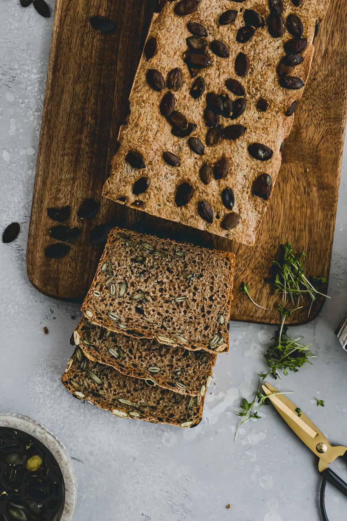 sliced pumpkin seed bread on a wooden board