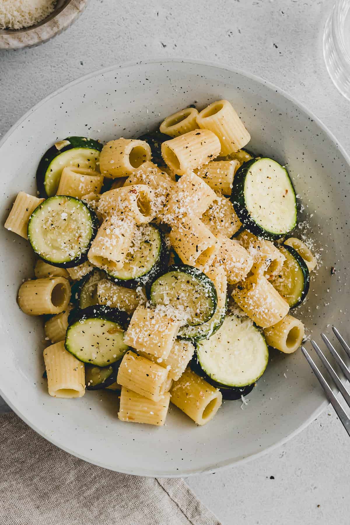 pasta with zucchini and parmesan cheese in a bowl