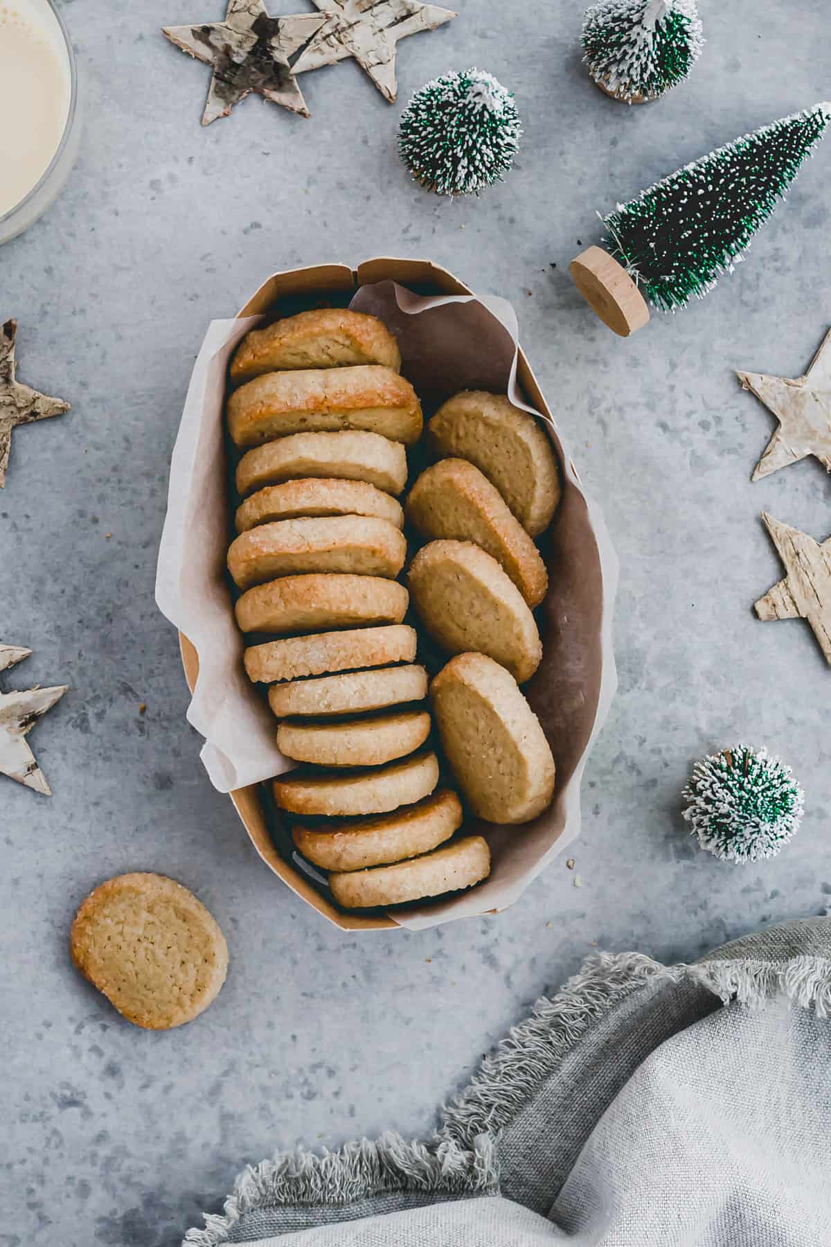 french butter cookies in a box next to a glass of milk