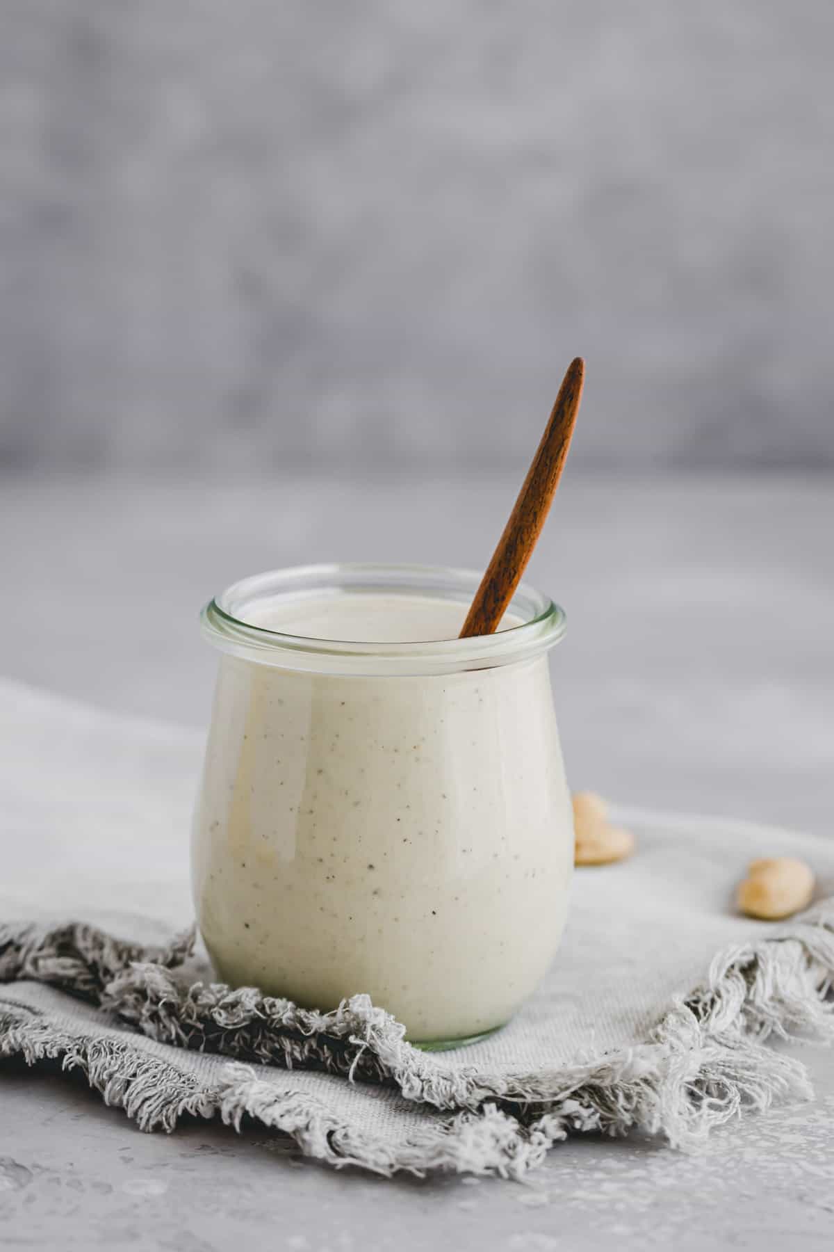 vegetarian caesar dressing in a jar with a wooden spoon