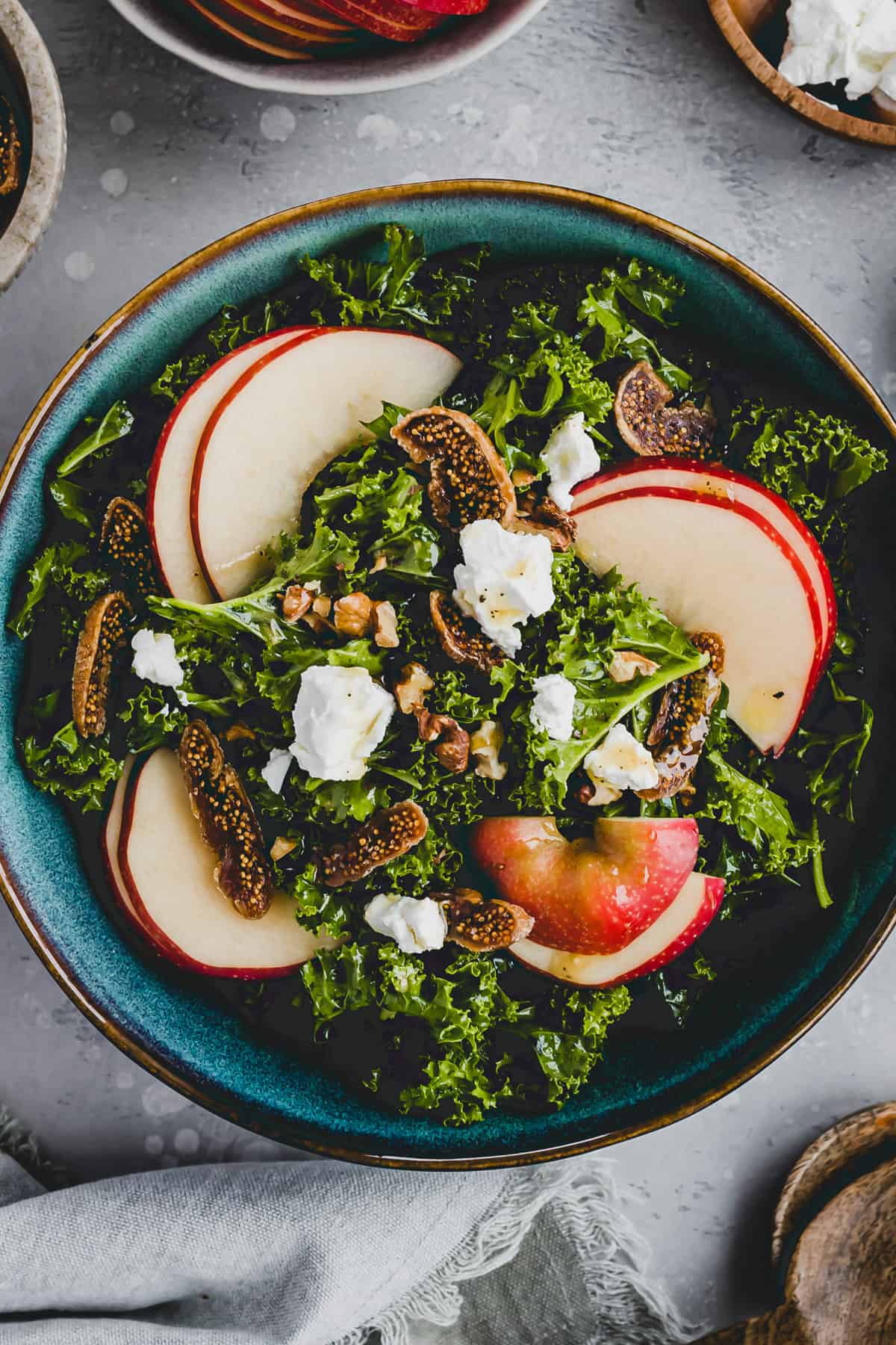 Kale salad with apples, figs, walnut and goat cheese in a salad bowl