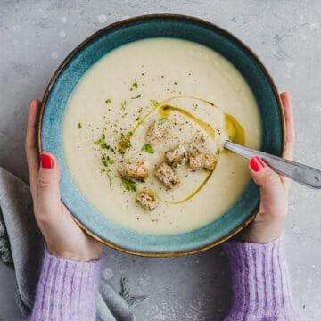 two hand holding a bowl of Apple Celeriac Soup