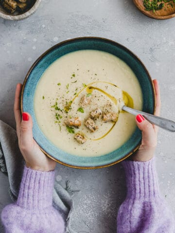 two hand holding a bowl of Apple Celeriac Soup