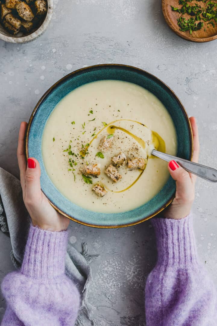 two hand holding a bowl of Apple Celeriac Soup