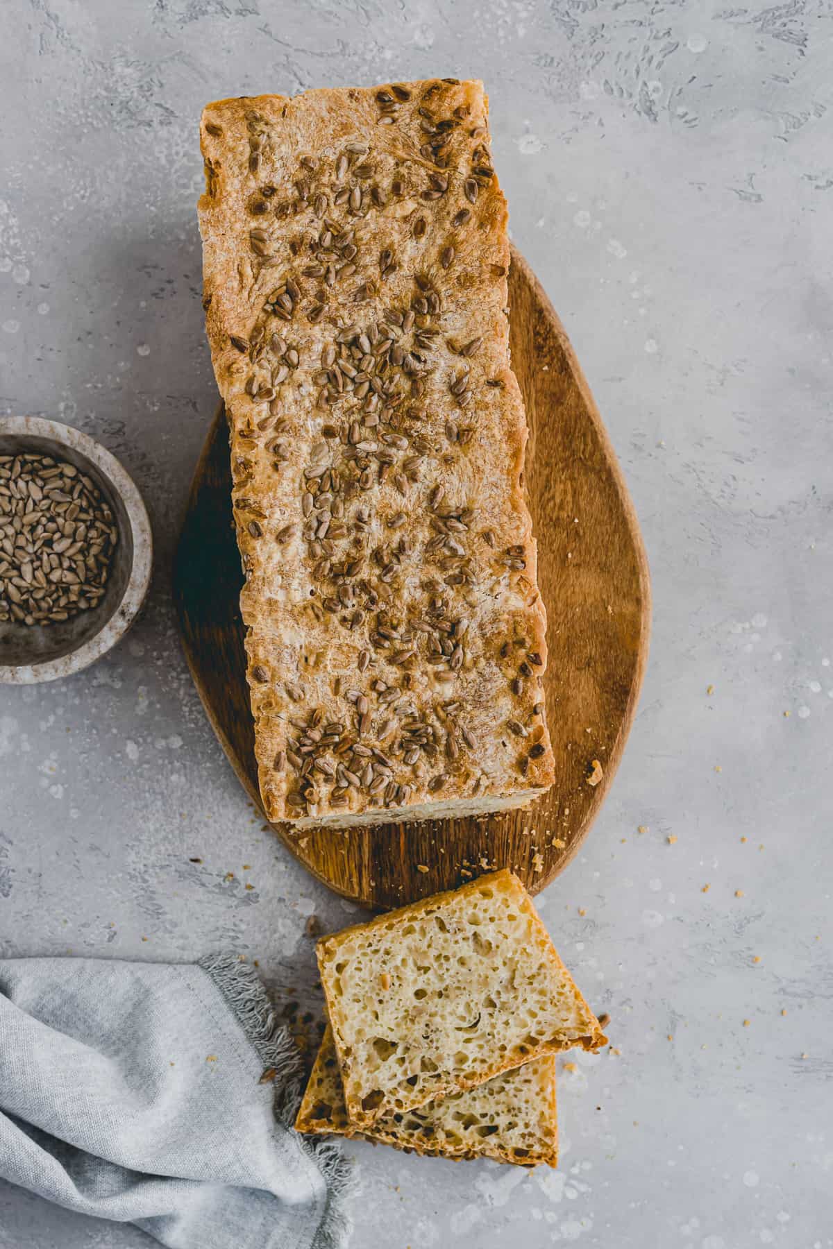 angeschnittenes sonnenblumenbrot auf einem brett