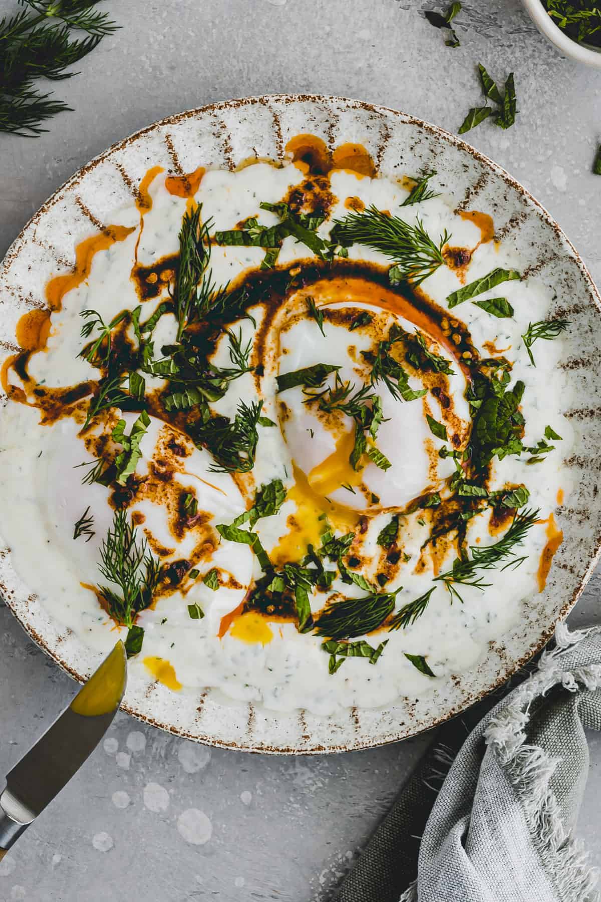 Turkish Eggs served on a plate with a knife