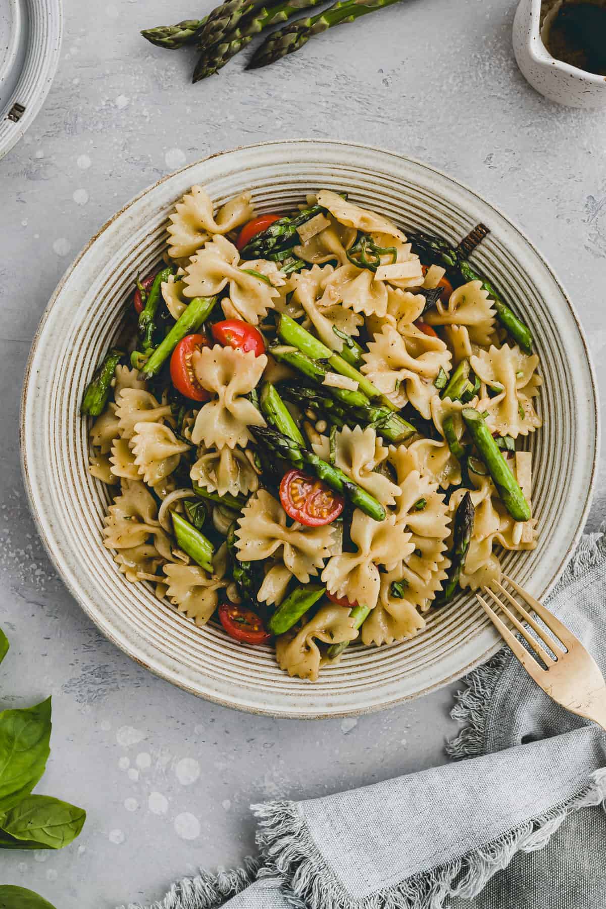 pasta salad with asparagus and cherry tomatoes in a bowl