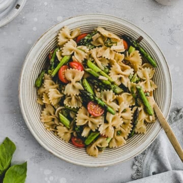 asparagus pasta salad in a bowl with a golden fork