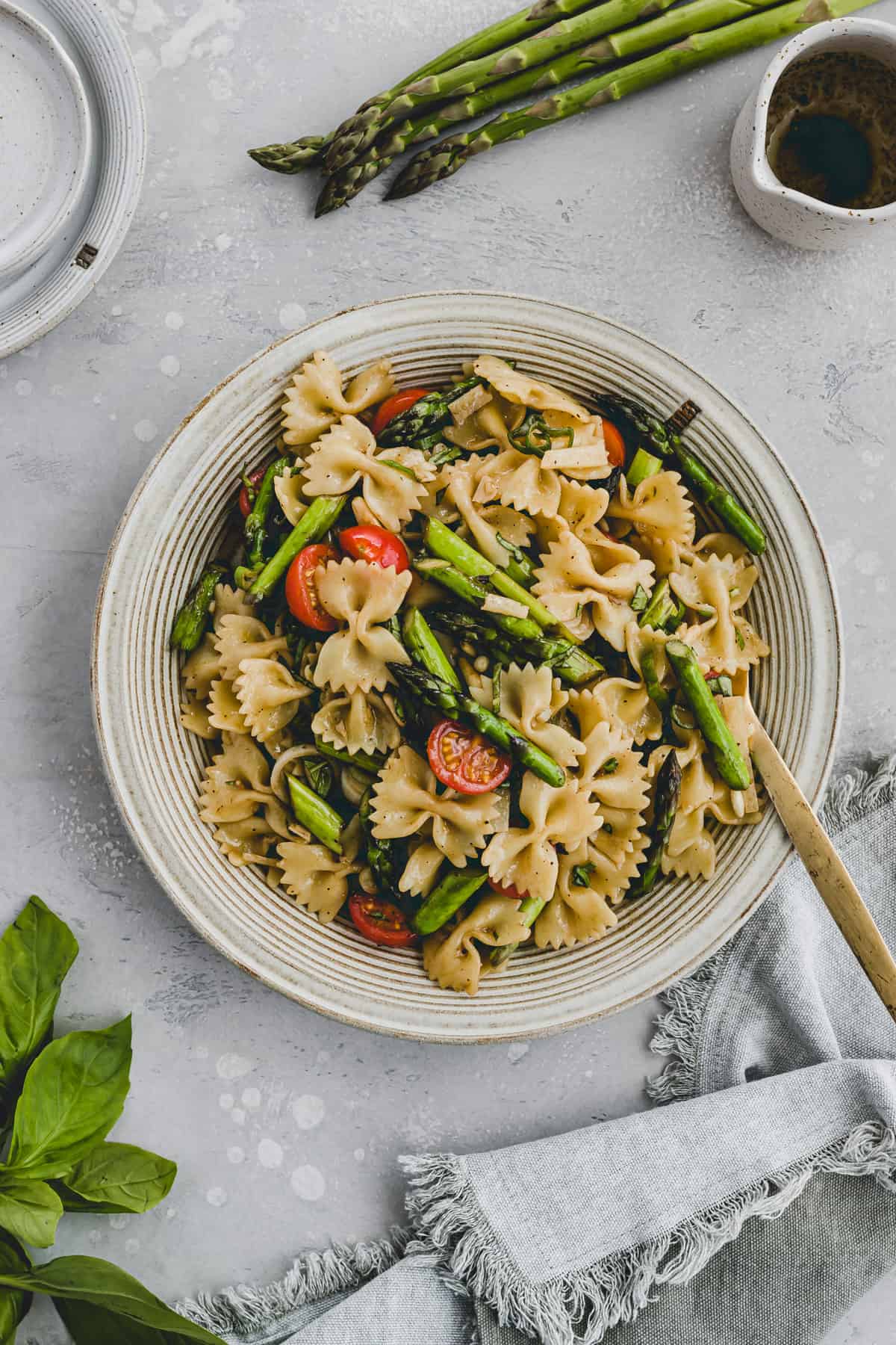 asparagus pasta salad in a bowl with a golden fork