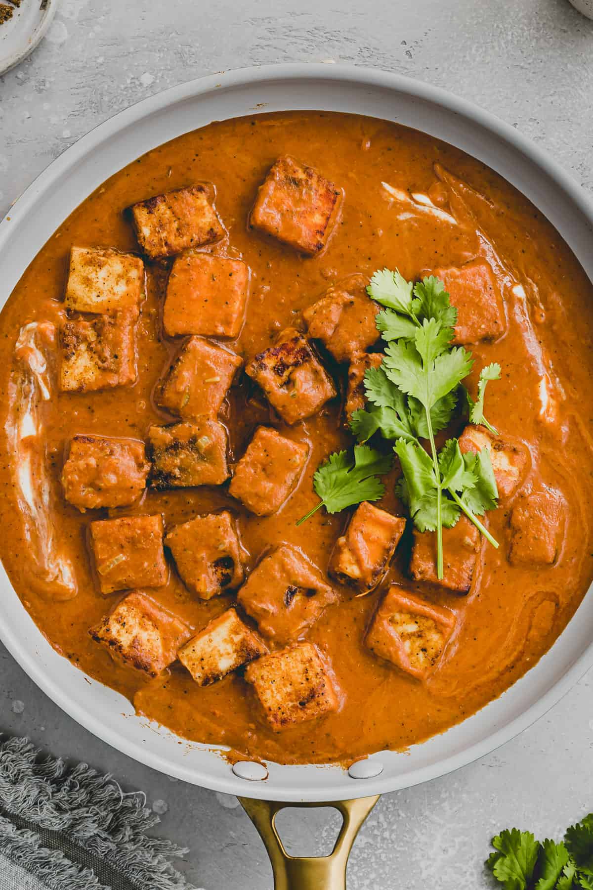 paneer tikka masala in einer pfanne mit koriander dekoriert