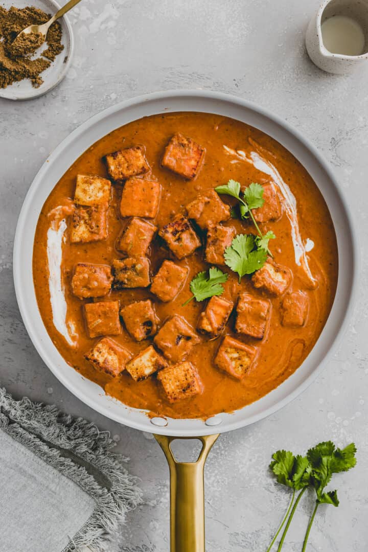 paneer tikka masala served in a skillet and topped with fresh cilantro