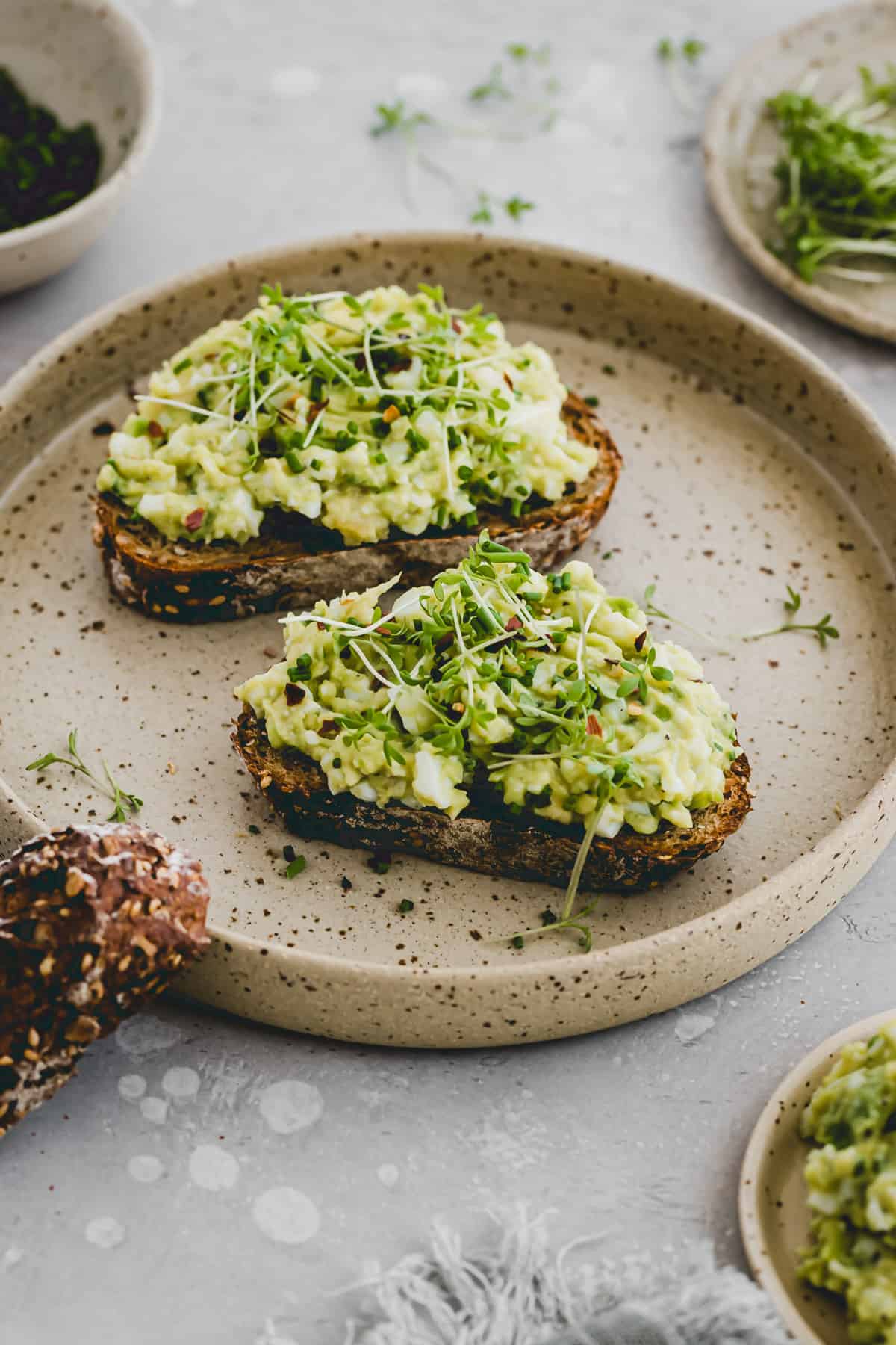 avocado ei salat auf brot mit kresse dekoriert