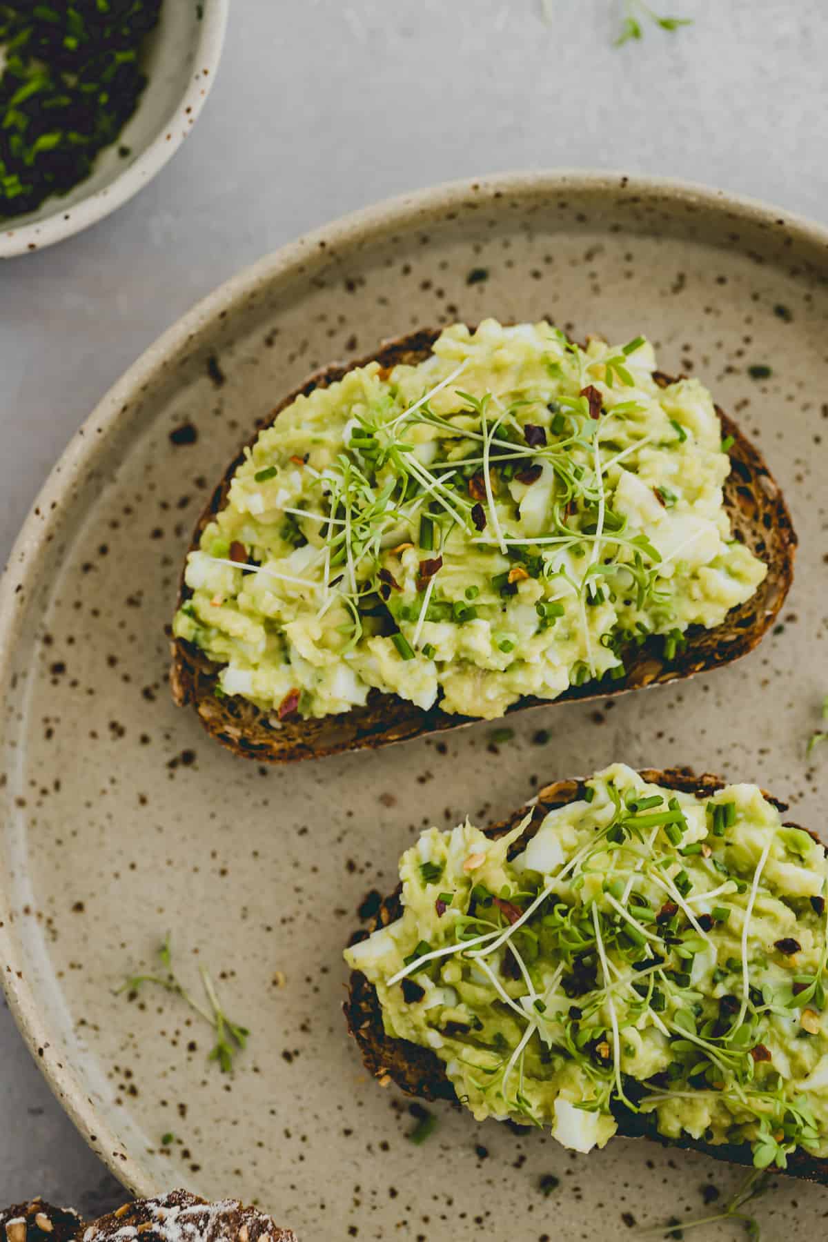 Avocado Egg Salad served on bread and garnished with microgreens