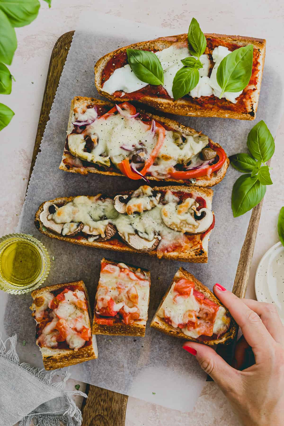 eine hand greift nach einem stück baguette pizza