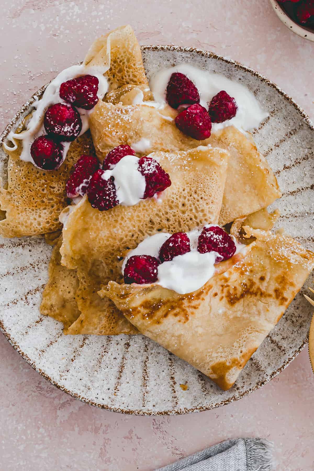 crepes served with powdered sugar and berries