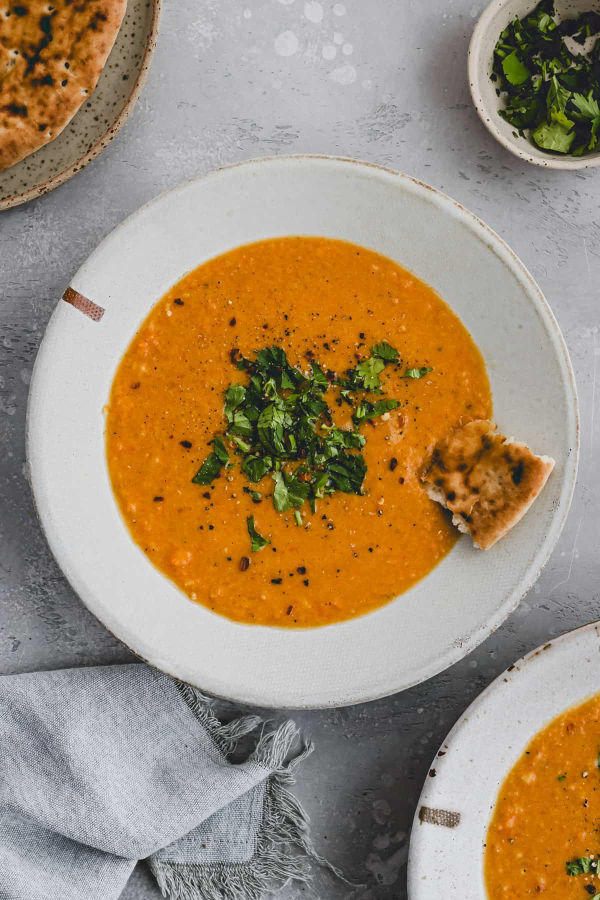 dal soup served in a bowl with naan bread