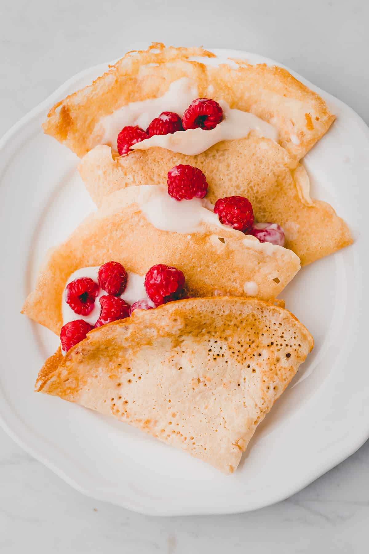 vegan crepes filled with raspberries on a plate