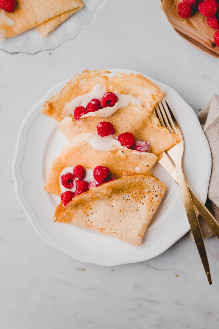 vegan french crepes filled with raspberries on a plate