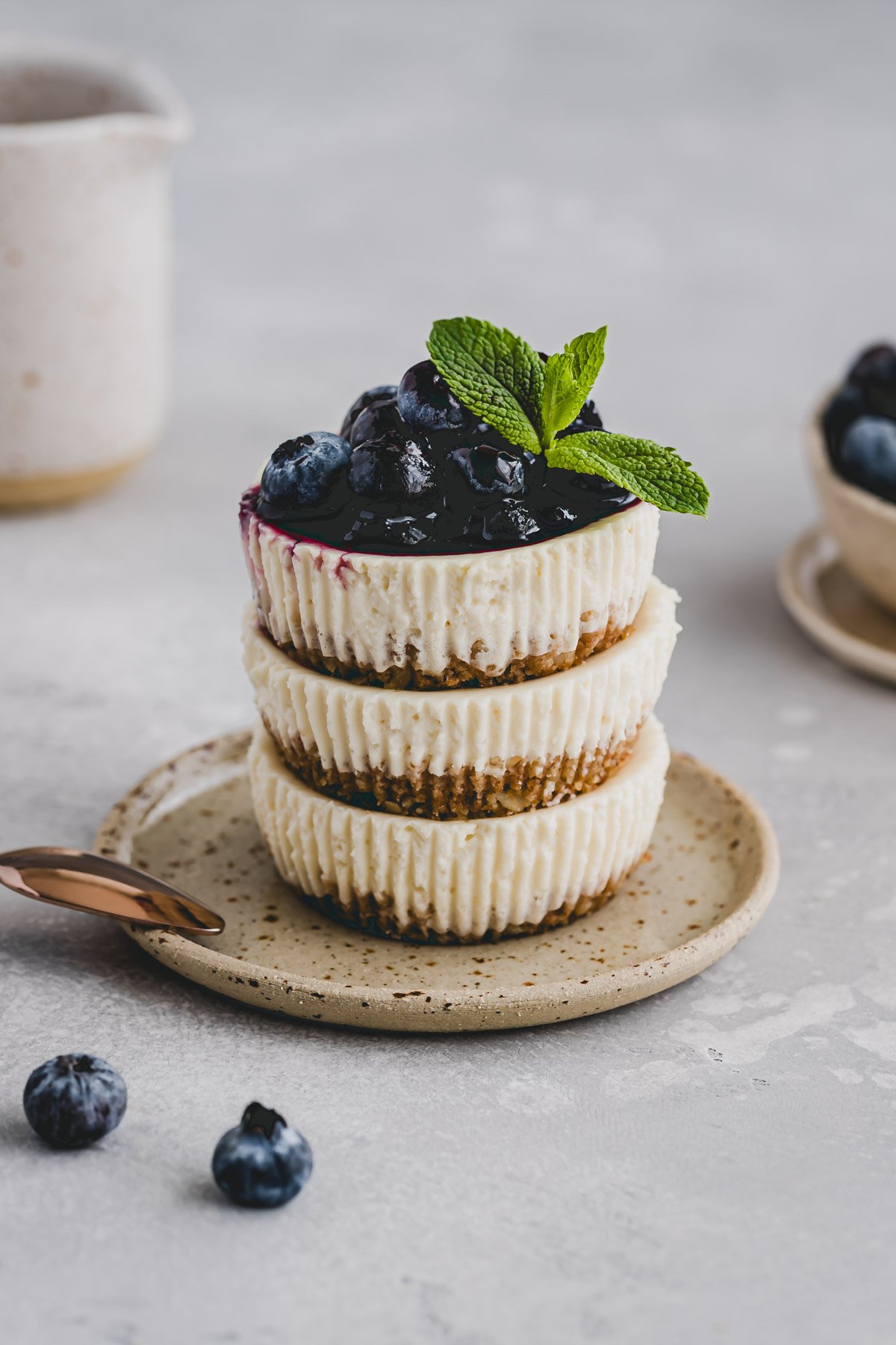 mini cheesecakes aufeinandergestapelt und mit blaubeeren dekoriert