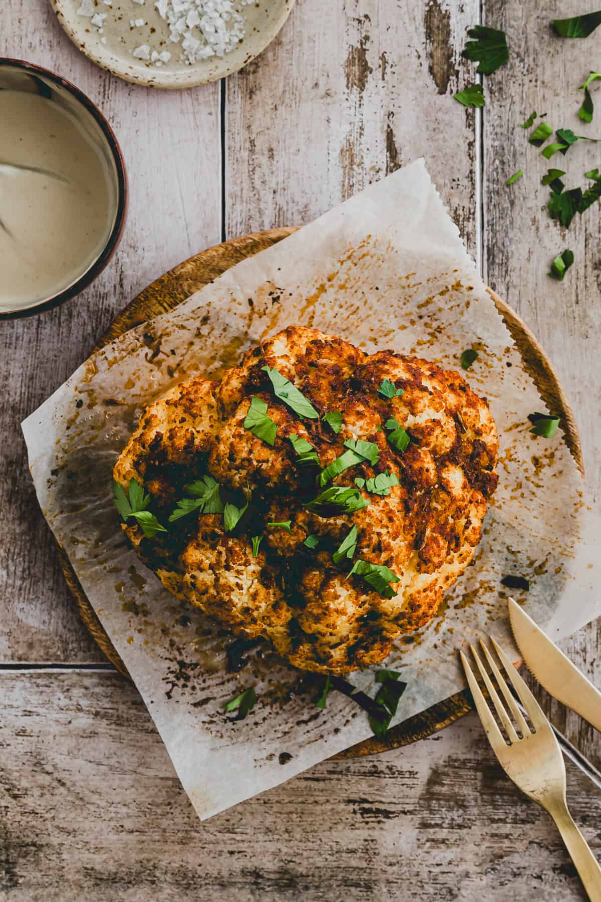 cauliflower head roasted in the oven and topped with parlsey