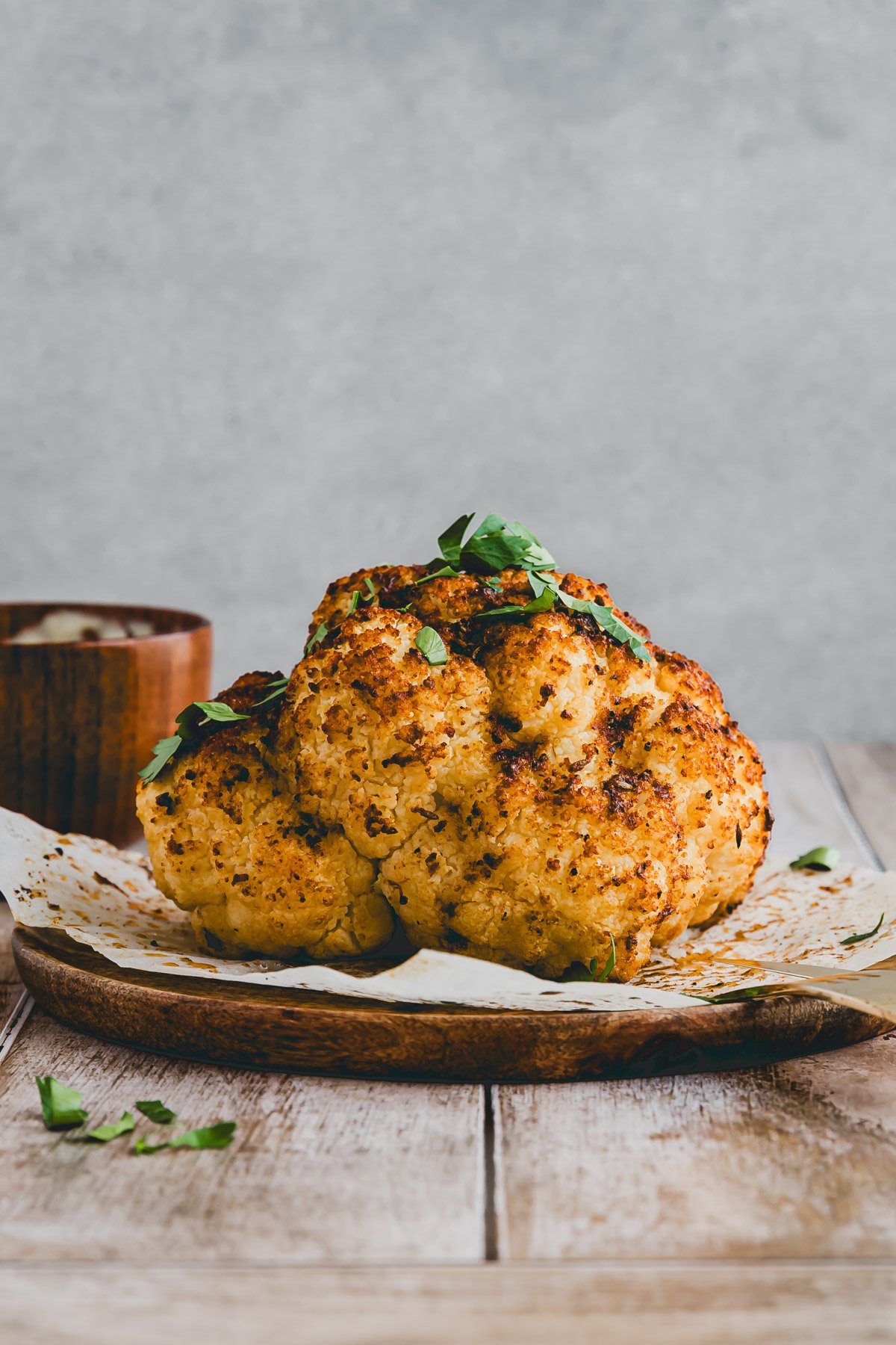 whole roasted cauliflower head topped with parsley