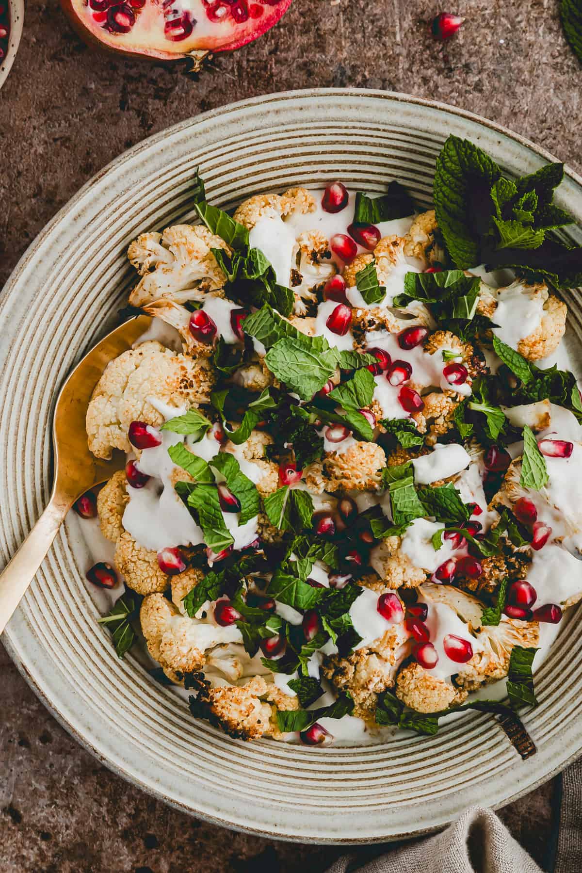 roasted cauliflower florets on a plate drizzled with tahini