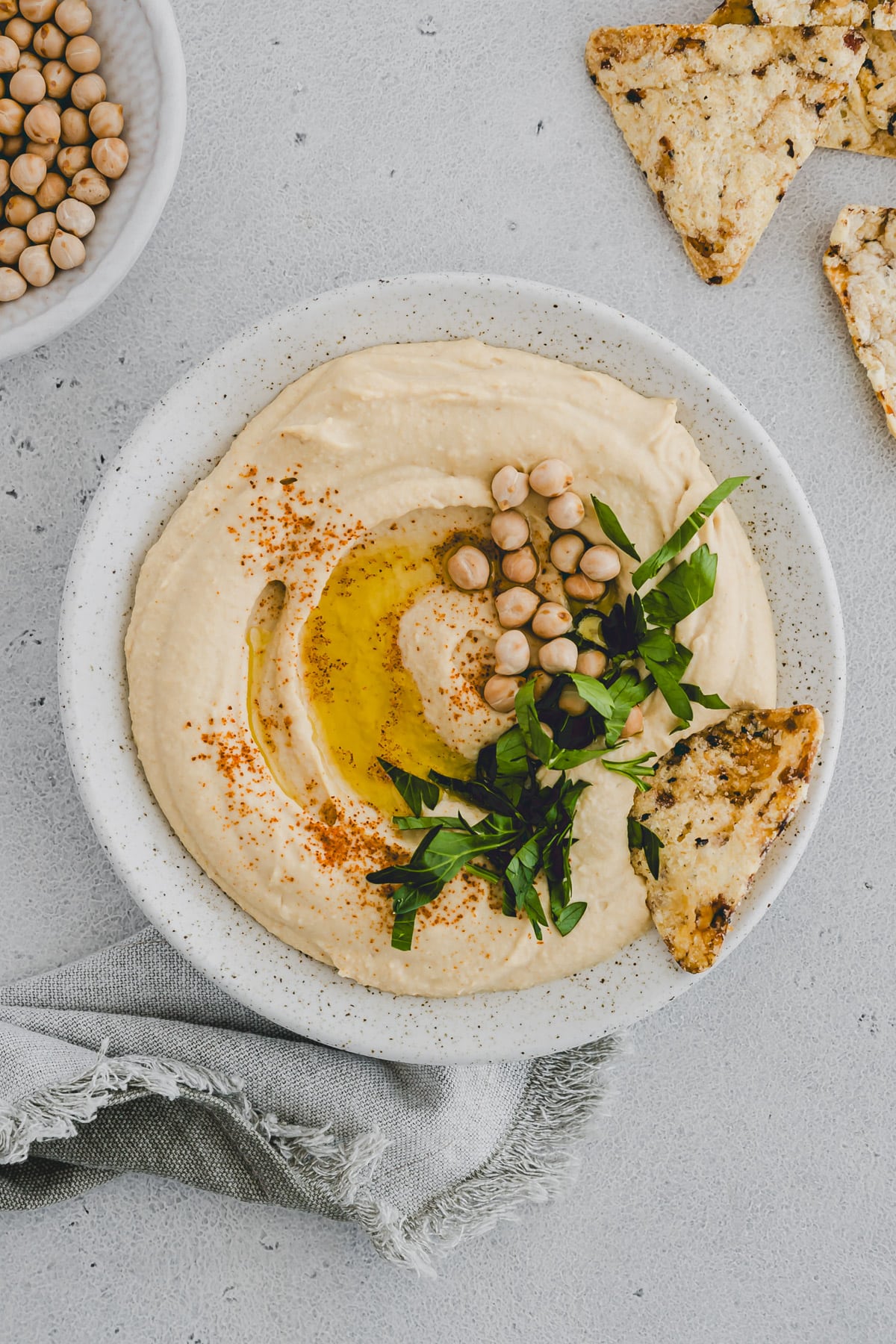 hummus mit kichererbsen, petersilie, und olivenöl dekoriert