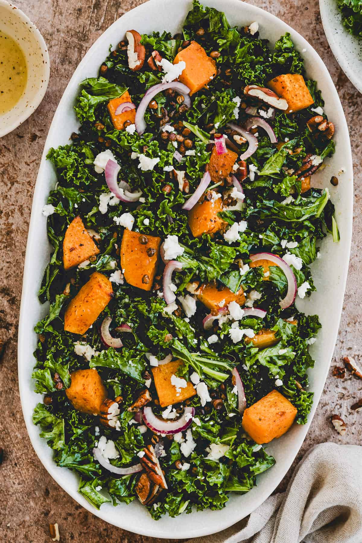 roasted butternut squash salad with kale, feat cheese, and lentils on a plate