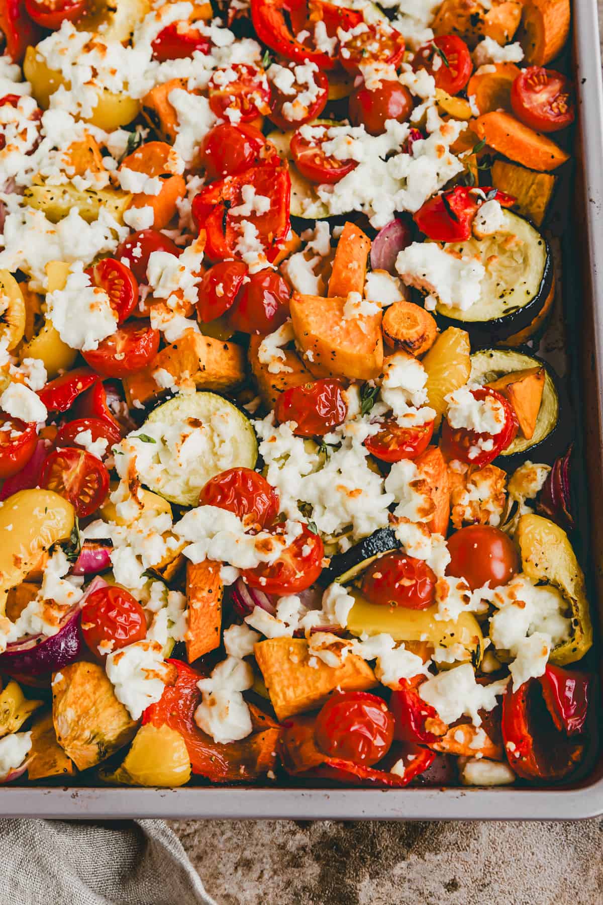 ein backblech mit buntem ofengemüse und feta