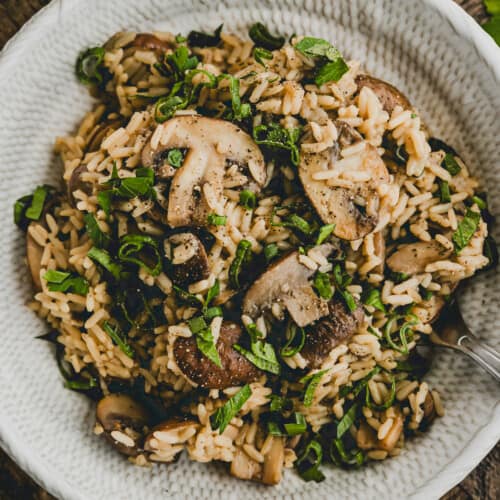 One Pot Mushroom Rice in a bowl garnished with parsley