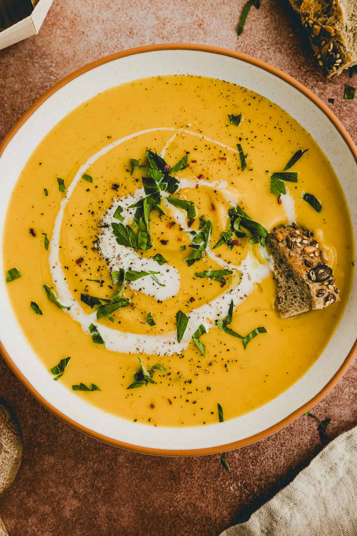 creamy red lentil soup in a bowl served with bread