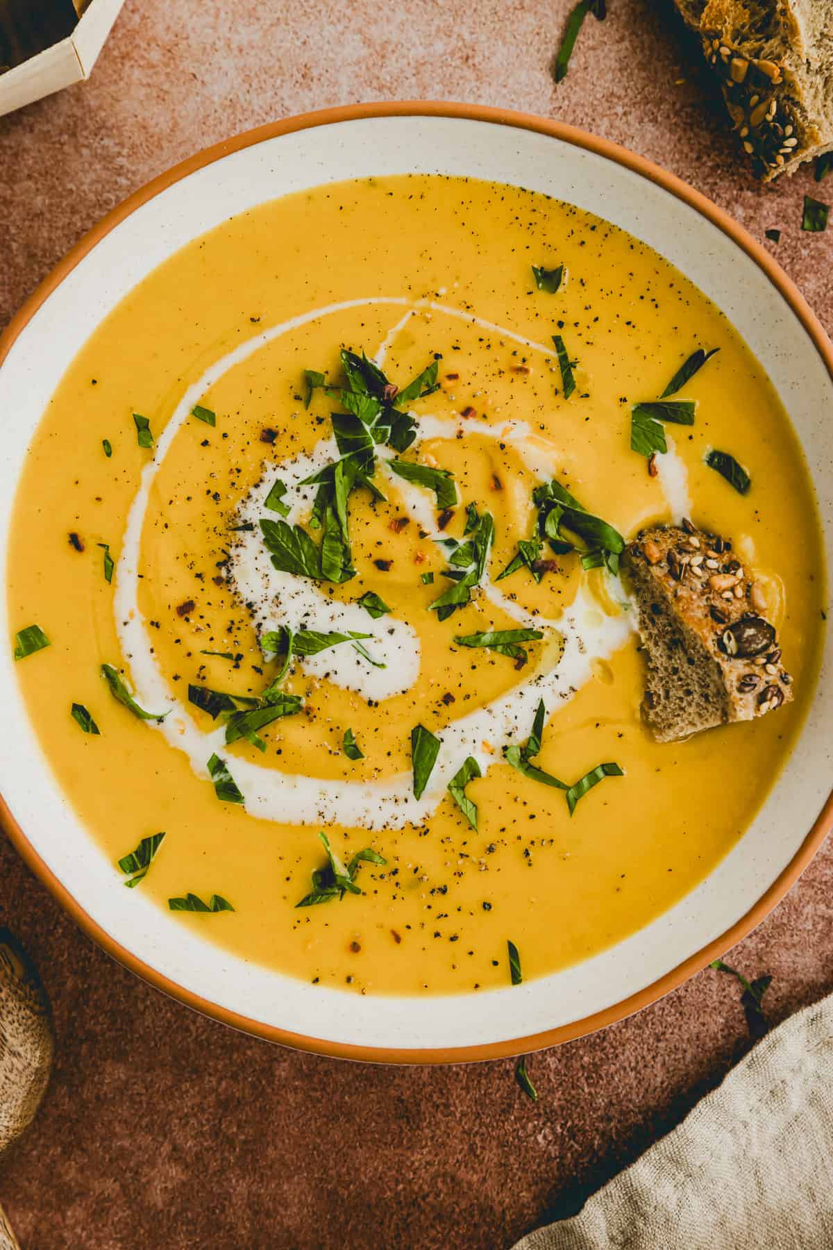 rote linsensuppe in einem teller mit einem stück brot