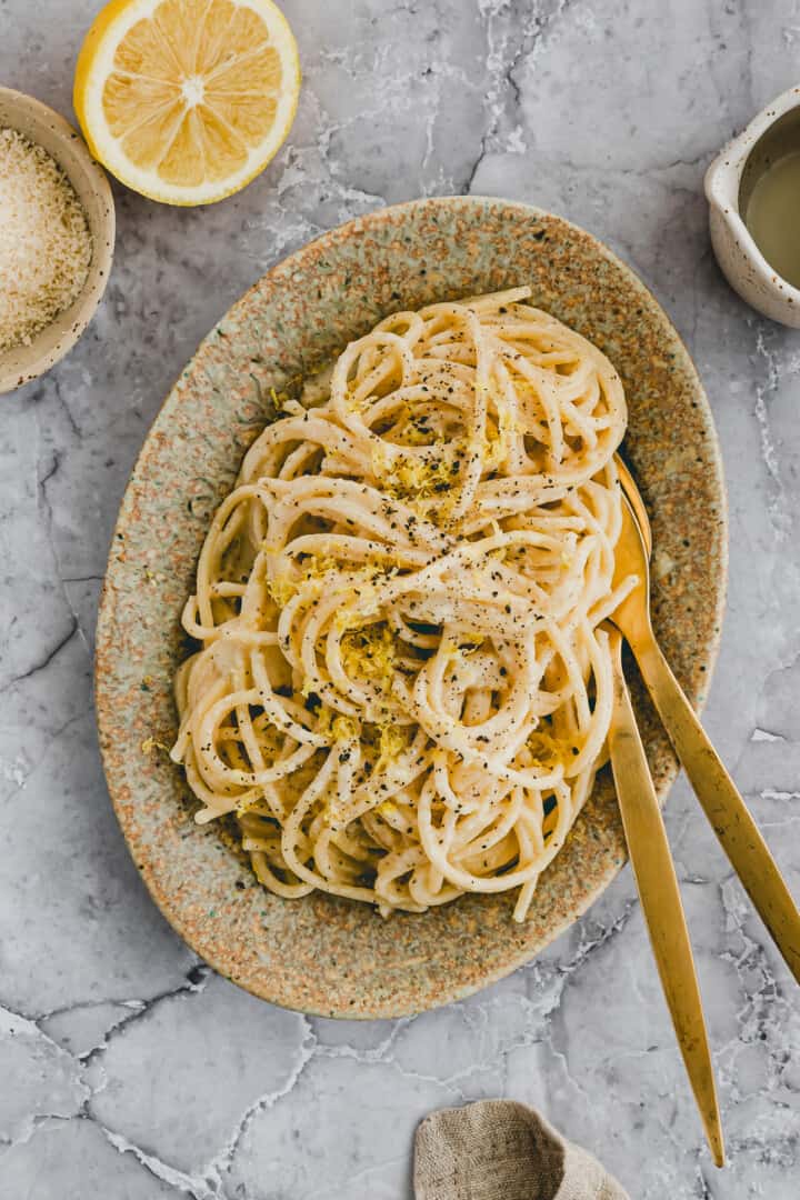 lemon pasta on a plate with golden cutlery