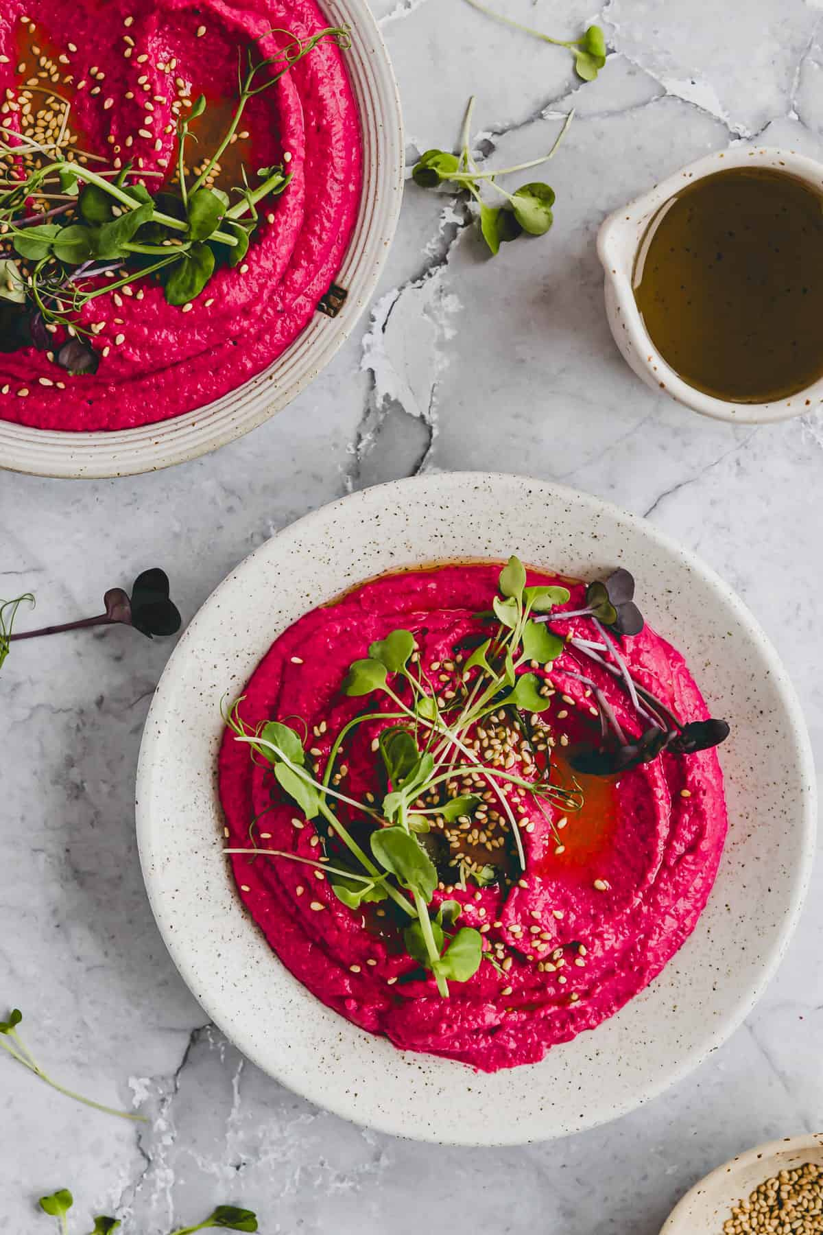 beetroot hummus served in a bowl and topped with microgreens