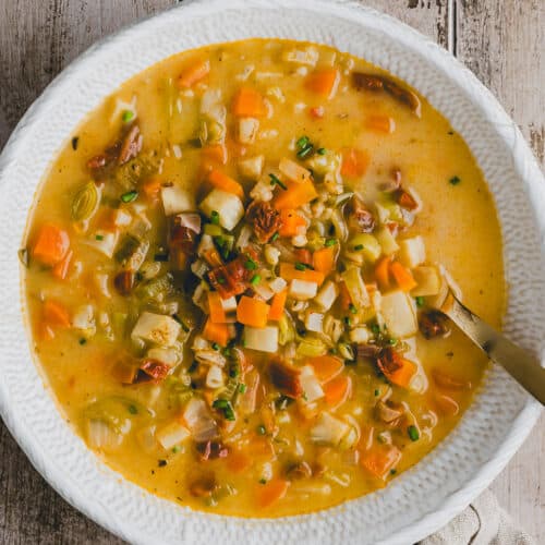 vegetarische gerstensuppe in einem weissen suppenteller