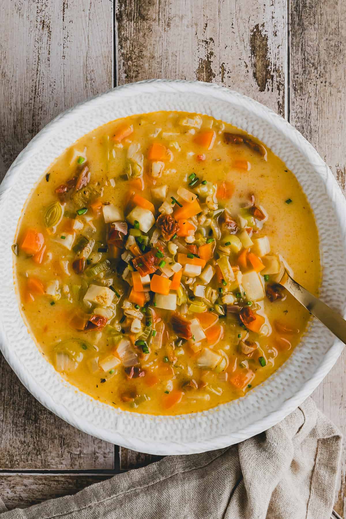 vegetarische gerstensuppe in einem weissen suppenteller