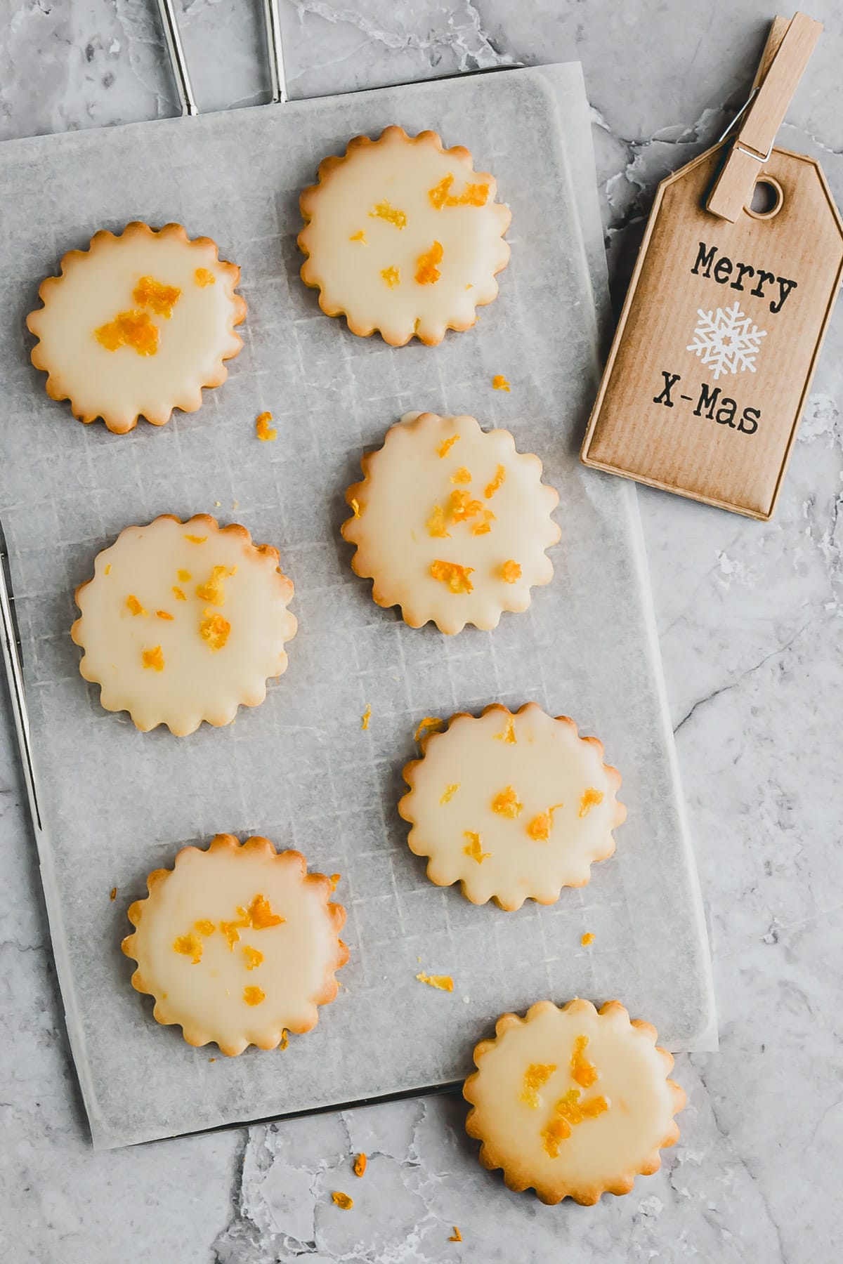 orangenplätzchen mit puderzuckerglasur auf einem gitter