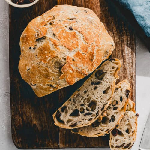 angeschnittenes olivenbrot auf einem holzbrett